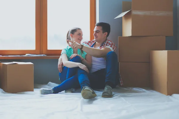 Par som flyttar i huset sitter på golvet. Par — Stockfoto