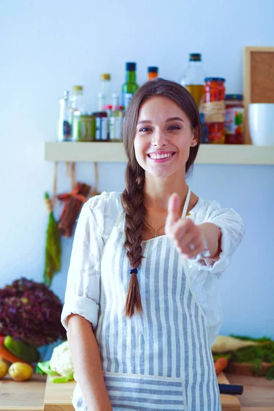 Mujer joven de pie cerca de escritorio en la cocina. Mujer joven . — Foto de Stock