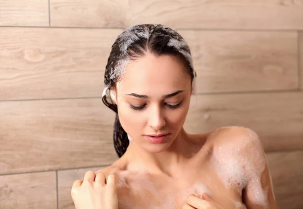 Jonge beautyful vrouw onder de douche in de badkamer. — Stockfoto