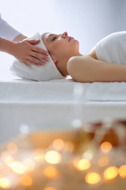 Masaj masasında uzanmış gözleri kapalı rahatlayan genç bir kadın. - Kadın. Spa salonu