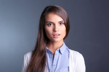 Esmer arka planda bir iş kadınının portresi. Gülümseyen kadın. Bir kadın portresi