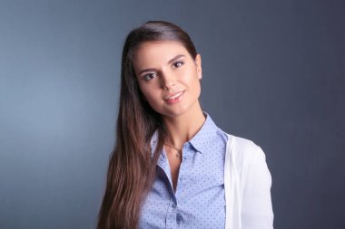 Esmer arka planda bir iş kadınının portresi. Gülümseyen kadın. Bir kadın portresi