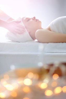 Masaj masasında uzanmış gözleri kapalı rahatlayan genç bir kadın. - Kadın. Spa salonu