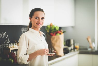 Giderleri planlama ve mutfağını faturalarında ödeme genç kadın.