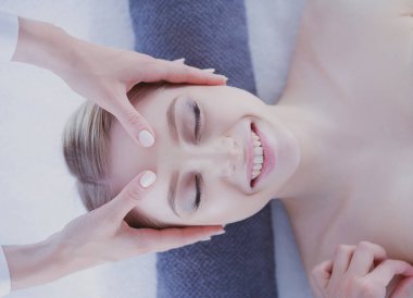 Masaj masasında uzanmış gözleri kapalı rahatlayan genç bir kadın. - Kadın. Spa salonu