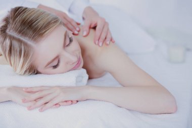 Masaj masasında uzanmış gözleri kapalı rahatlayan genç bir kadın. - Kadın. Spa salonu