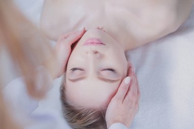 Masaj masasında uzanmış gözleri kapalı rahatlayan genç bir kadın. - Kadın. Spa salonu