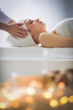 Masaj masasında uzanmış gözleri kapalı rahatlayan genç bir kadın. - Kadın. Spa salonu