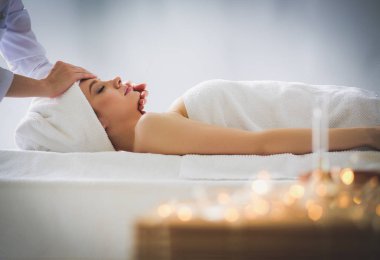 Masaj masasında uzanmış gözleri kapalı rahatlayan genç bir kadın. - Kadın. Spa salonu