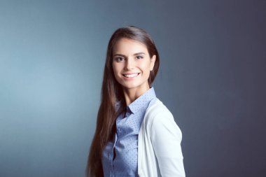 Esmer arka planda bir iş kadınının portresi. Gülümseyen kadın. Bir kadın portresi