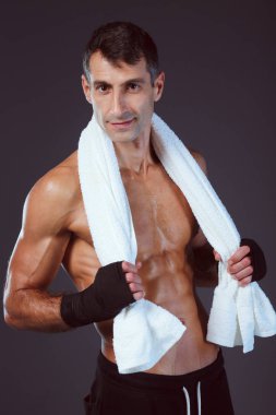 Siyah arka plan üzerine ayakta güçlü atletik adam.