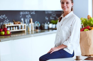 Giderleri planlama ve mutfağını faturalarında ödeme genç kadın.