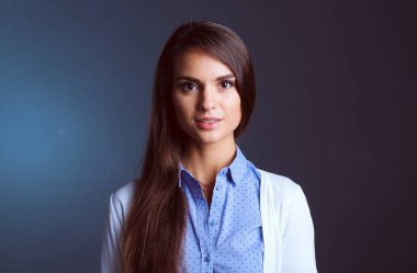 Esmer arka planda bir iş kadınının portresi. Gülümseyen kadın. Bir kadın portresi