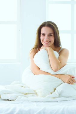 Yatağında evde oturan güzel kadın