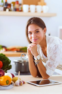 Mutfakta ipad 'ini kullanan genç bir kadın. Genç kadın.