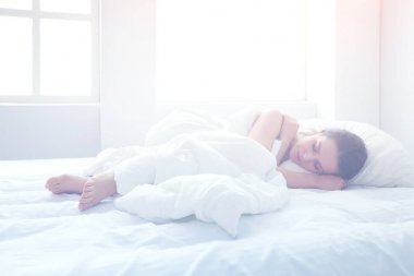 Güzel bir kadın yatağında uzanıyor.