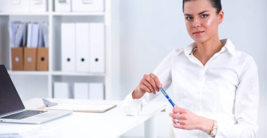 Ofiste dizüstü bilgisayarı olan çekici bir iş kadını.