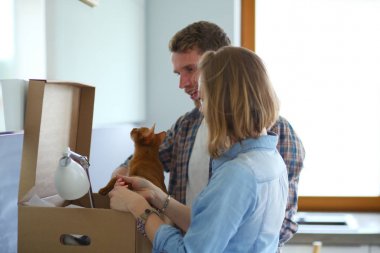 Genç bir çift yeni evde büyük karton kutu taşıyan. Ev taşıma. Genç Çift