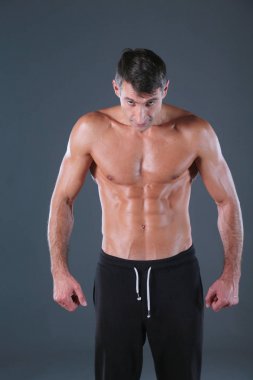 kaslı adam. Kaslı adam kas gösterilen gri arka plan üzerinde. Fitness Eğitmeni. Fitness profesyonel. Egzersiz. Mens fitness.