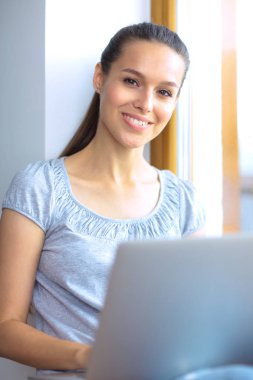 Evde bir dizüstü bilgisayar kullanan genç güzel kadın. Genç güzel kadın.