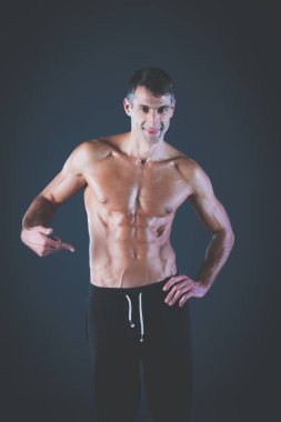 kaslı adam. Kaslı adam kas gösterilen gri arka plan üzerinde. Fitness Eğitmeni. Fitness profesyonel. Egzersiz. Mens fitness.