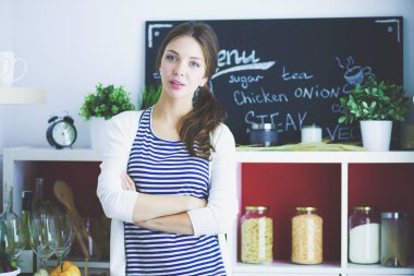 Mutfakta masanın yanında duran genç bir kadın. Genç kadın. .