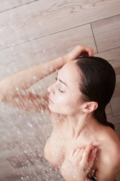 Joven mujer hermosa bajo la ducha en el baño . — Foto de Stock