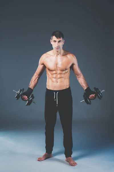 Hombre musculoso guapo haciendo ejercicio con pesas. Instructor de fitness personal. Formación personal . —  Fotos de Stock
