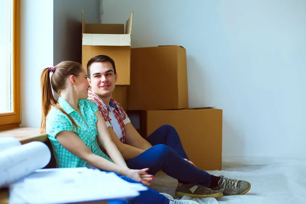 Paar zieht im Haus auf dem Fußboden sitzend ein. Paar — Stockfoto