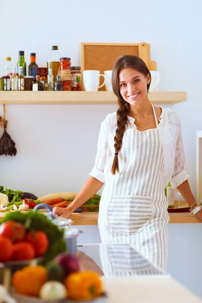 Mujer joven de pie cerca de escritorio en la cocina. Mujer joven . —  Fotos de Stock