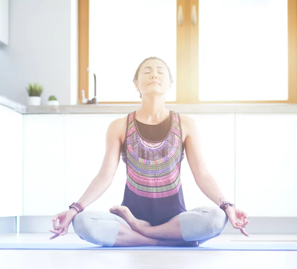 Mujer joven haciendo yoga en casa en la posición de loto. Yoga. Una mujer. Estilo de vida — Foto de Stock