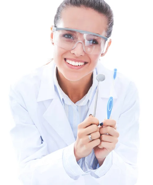 Красива жінка-стоматолог, яка тримає і показує зубну щітку ізольовано на білому тлі — стокове фото
