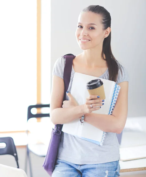 Retrato de una joven estudiante sosteniendo libros de ejercicios. Estudiante mujer — Foto de Stock