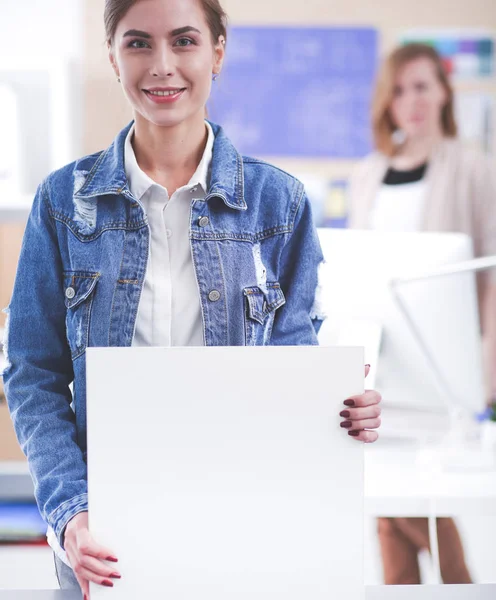 Two young woman standing near desk with instruments, plan and laptop. — Stock Photo, Image
