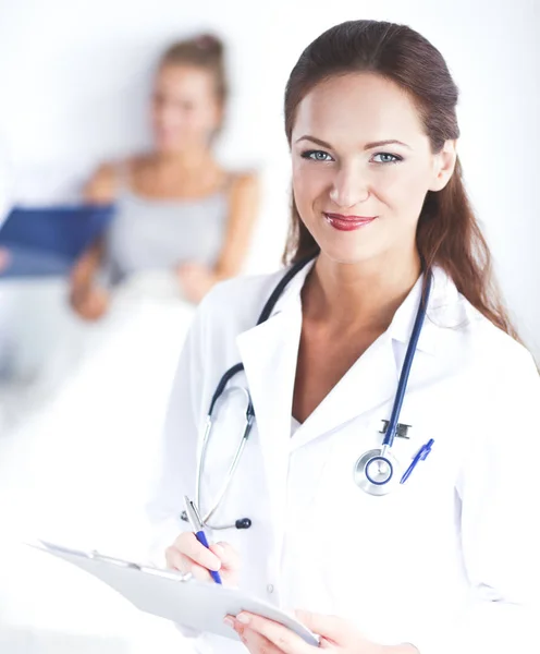 Sorridente medico donna con una cartella in uniforme in piedi in ospedale — Foto Stock