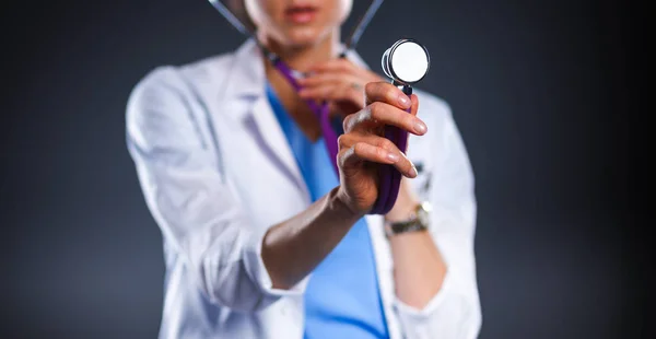 Female doctor with a stethoscope listening, isolated on grey background — Stock Photo, Image