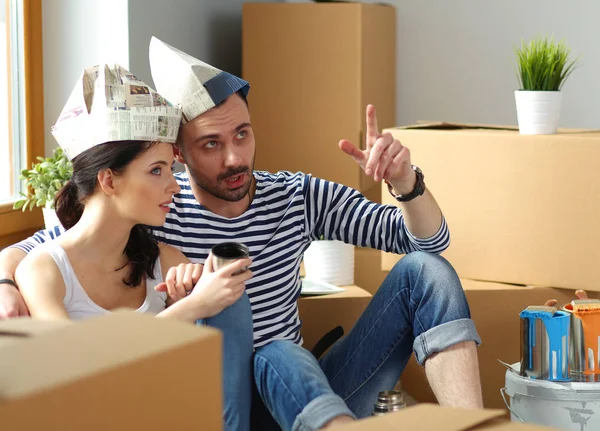 Couple moving in house sitting on the floor . Couple