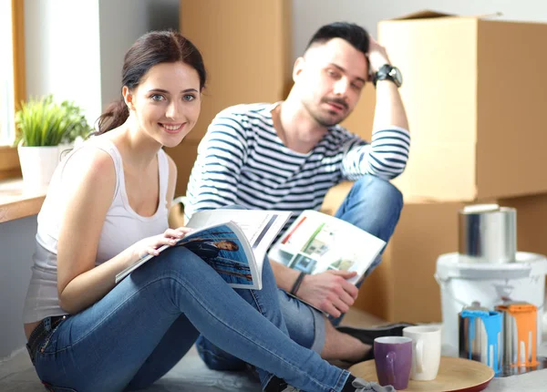 Paar zieht im Haus auf dem Fußboden sitzend ein. Paar — Stockfoto