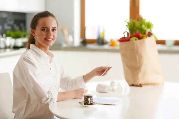 Joven mujer planeando gastos y pagando facturas en su cocina . —  Fotos de Stock