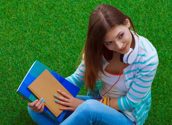 Ung kvinna med laptop sitter på grönt gräs. Porträtt ung kvinna — Stockfoto