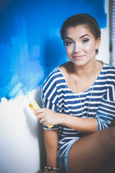 Beautiful young woman doing wall painting, standing on ladder. Beautiful young woman — Stock Photo, Image