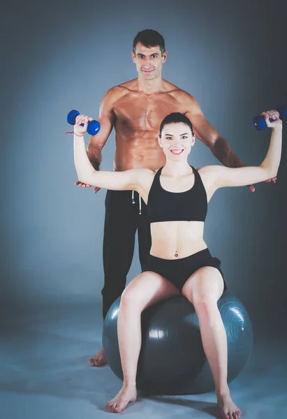 Dos personas sonrientes con pelota de fitness en el gimnasio. Instructor de fitness personal. Entrenamiento personal. Entrenamiento en el gimnasio . —  Fotos de Stock