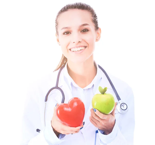 Beautiful smiling female doctor holding red heart and green apple. Woman doctor — Stock Photo, Image