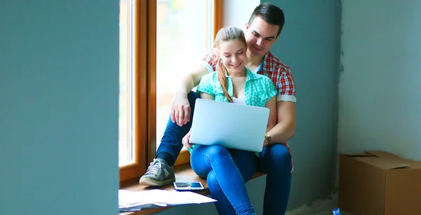Para się w nowym domu i korzystanie z bezprzewodowego dostępu do Internetu na komputerze typu tablet — Zdjęcie stockowe