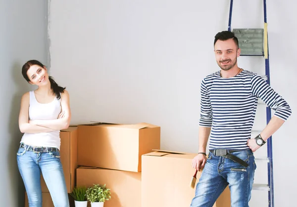 Jonge gelukkige paar in de kamer met de verhuisdozen nieuwe thuis — Stockfoto