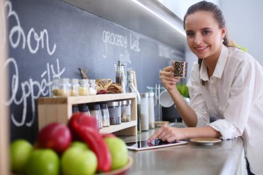 mutfak arka planı duran genç bir kadın portresi.