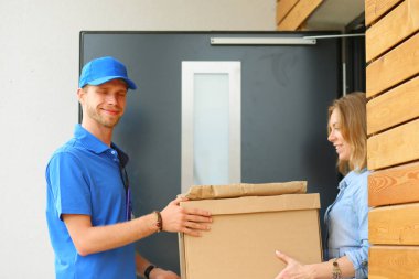 Mavi üniformalı gülümseyen kurye servis konseptine paket kutusu teslim eden teslimatçı. Mavi üniformalı gülümseyen teslimatçı.