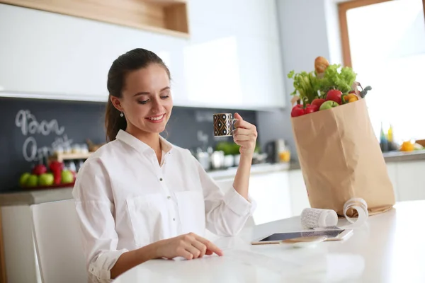 Young woman planning expenses and paying bills on her kitchen. — Stock Photo, Image