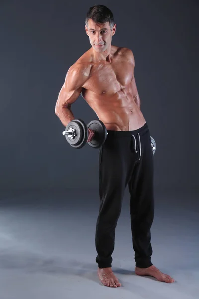Hombre musculoso guapo haciendo ejercicio con pesas. Instructor de fitness personal. Formación personal . —  Fotos de Stock