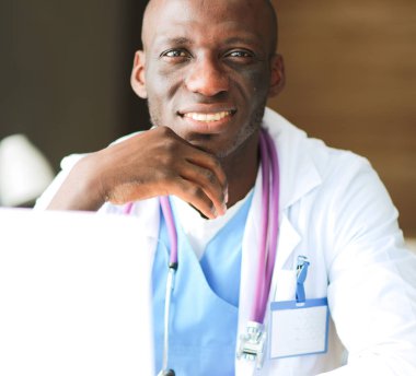 Masada dizüstü bilgisayarda çalışan genç bir Afrikalı doktor.